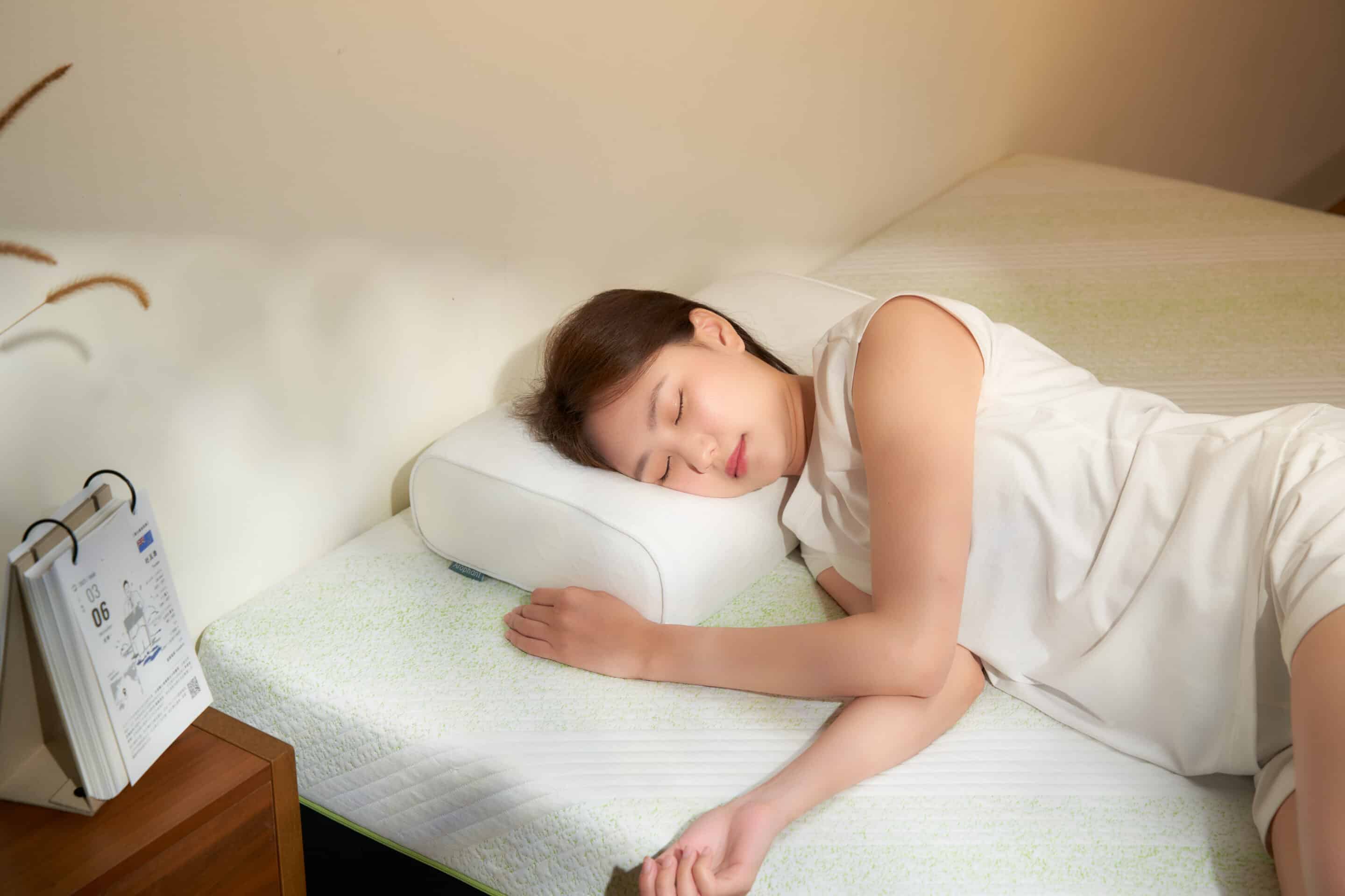 一位女生側躺在好睡象床墊及全能適壓枕上面