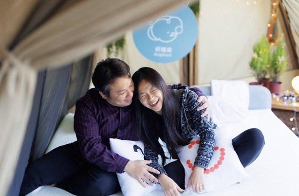 一對夫妻坐在好睡象適壓床上開心的笑著